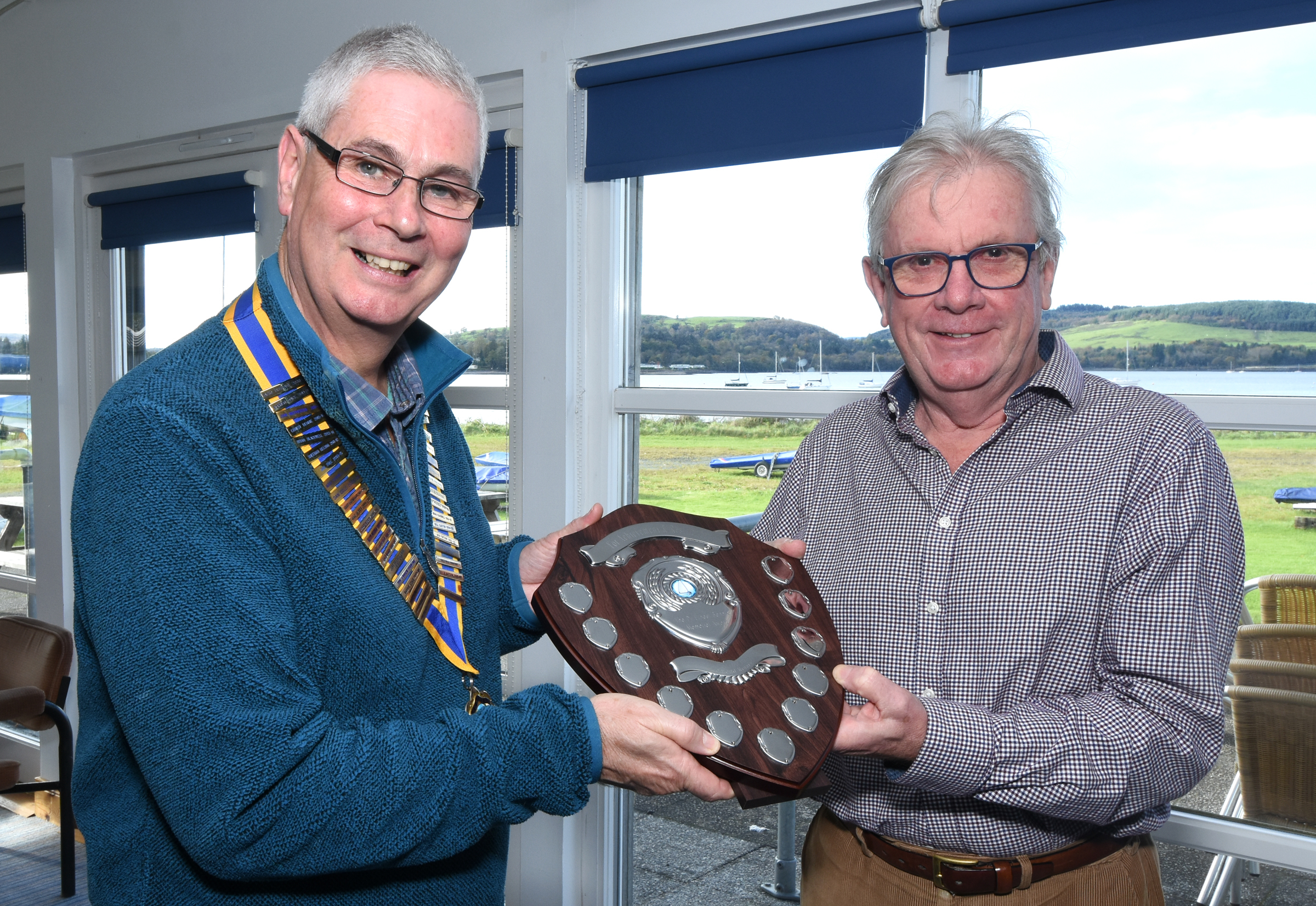Lomond Rotary president Gordon Greig hands over the new Ernest Bennie Memorial Trophy to David Whitham from the Helensburgh Challenger Group (Image: Brian Averell)