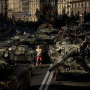 People walk around destroyed Russian military vehicles installed in downtown Kyiv, Ukraine, Wednesday, Aug. 24, 2022. Kyiv authorities have banned mass gatherings in the capital through Thursday for fear of Russian missile attacks. Independence Day, like