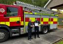 Watch Commander William Bellshaw, left, at Cove Fire Station, receives a certificate recognising 30 years