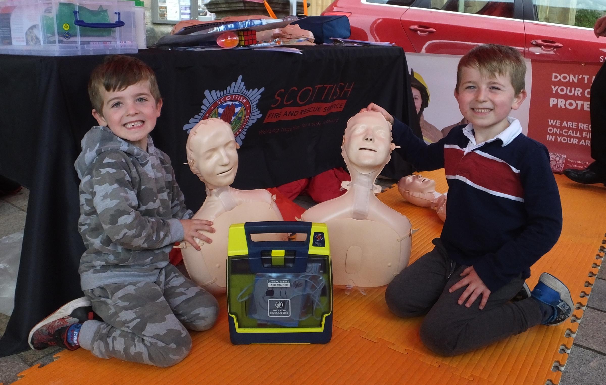 Rory and Alfie Cowan learn about life-saving techniques at the SFRS stall