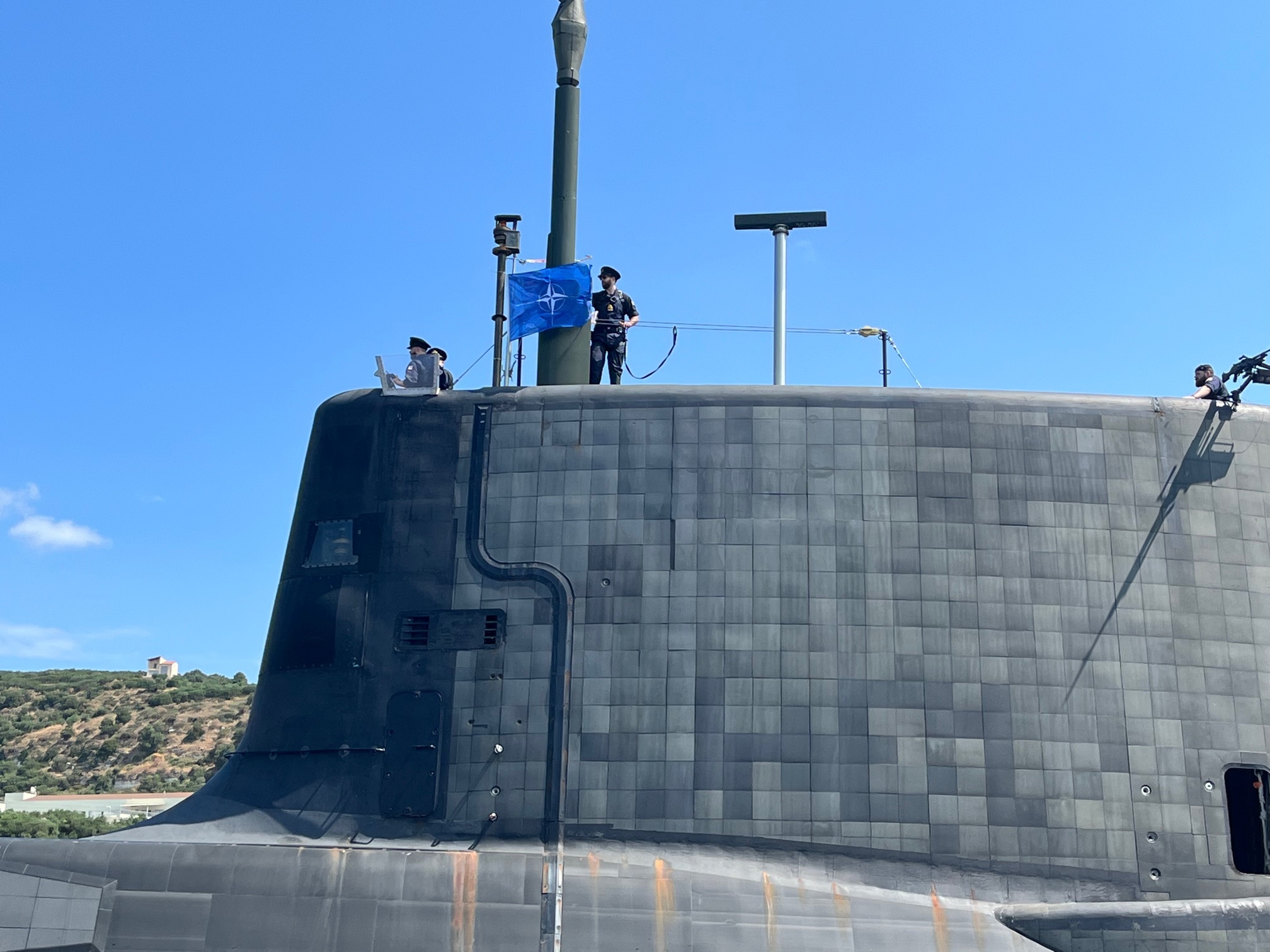 HMS Audacious departs Souda Bay in Crete ahead of NATO training and operations in the Mediterranean. The Astute-class submarine was on her first operational deployment from January 2022. Audacious can be seen flying the NATO pennant on her departure from