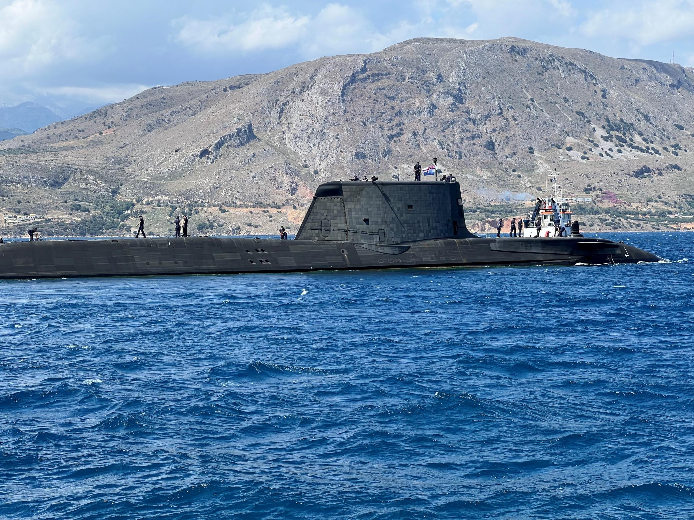 HMS Audacious departs Souda Bay in Crete ahead of NATO training and operations in the Mediterranean. The Astute-class submarine was on her first operational deployment from January 2022. Audacious can be seen flying the NATO pennant on her departure from
