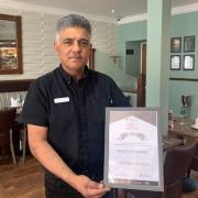 Manager Rocky holding the restaurant's award