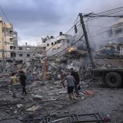 Palestinians walk amid the rubble following Israeli airstrikes in Gaza City after Hamas attacks killed more than 900 civilians (AP Photo/Fatima Shbair)