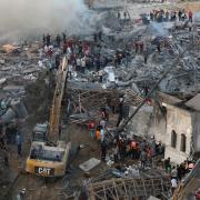 Palestinians inspect the damage of destroyed buildings following Israeli airs trikes on Gaza City